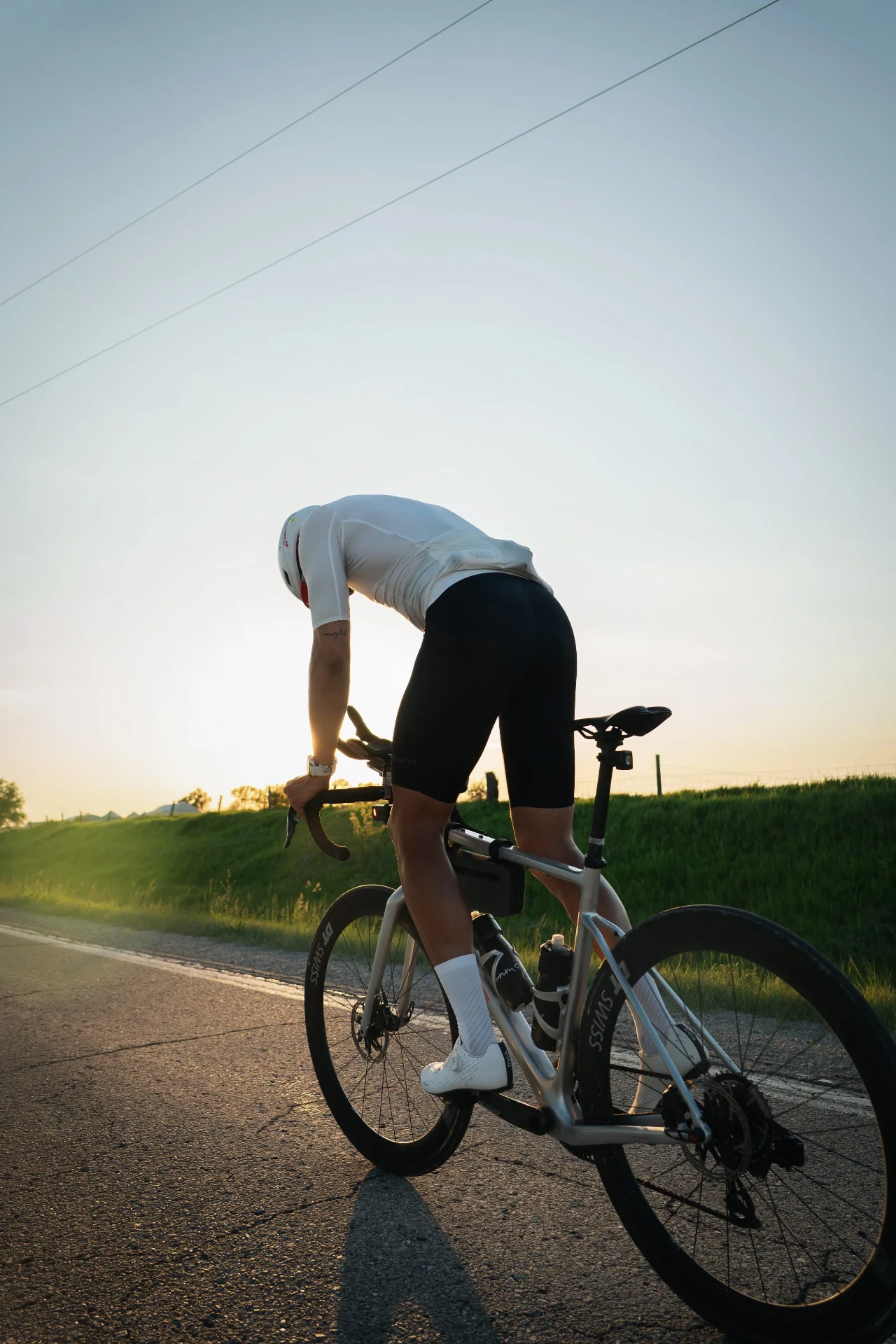 Peter Bolliger leaning over his bicycle at sunset