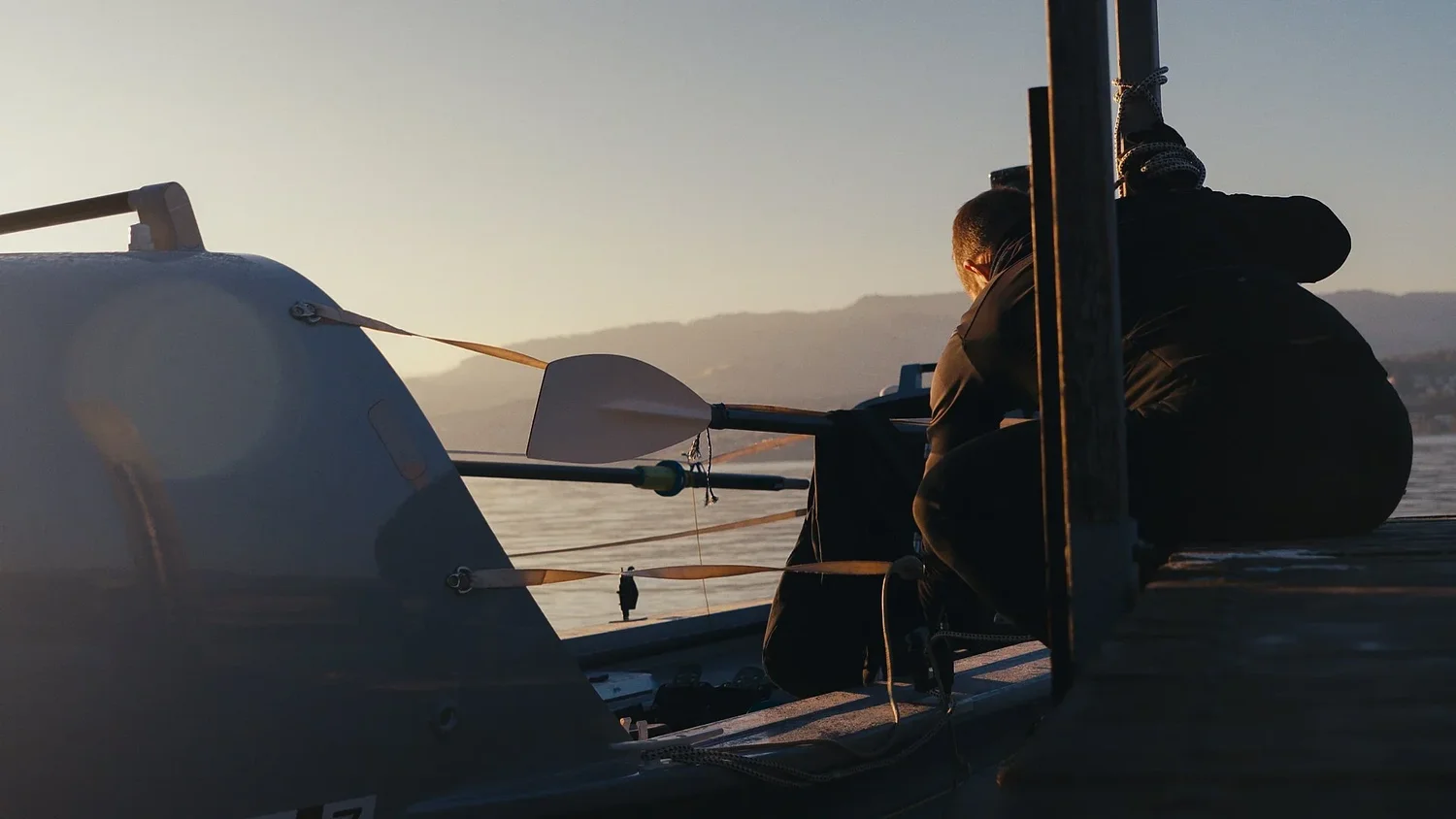 Ocean rowing boat moored beside a dock with spare oars