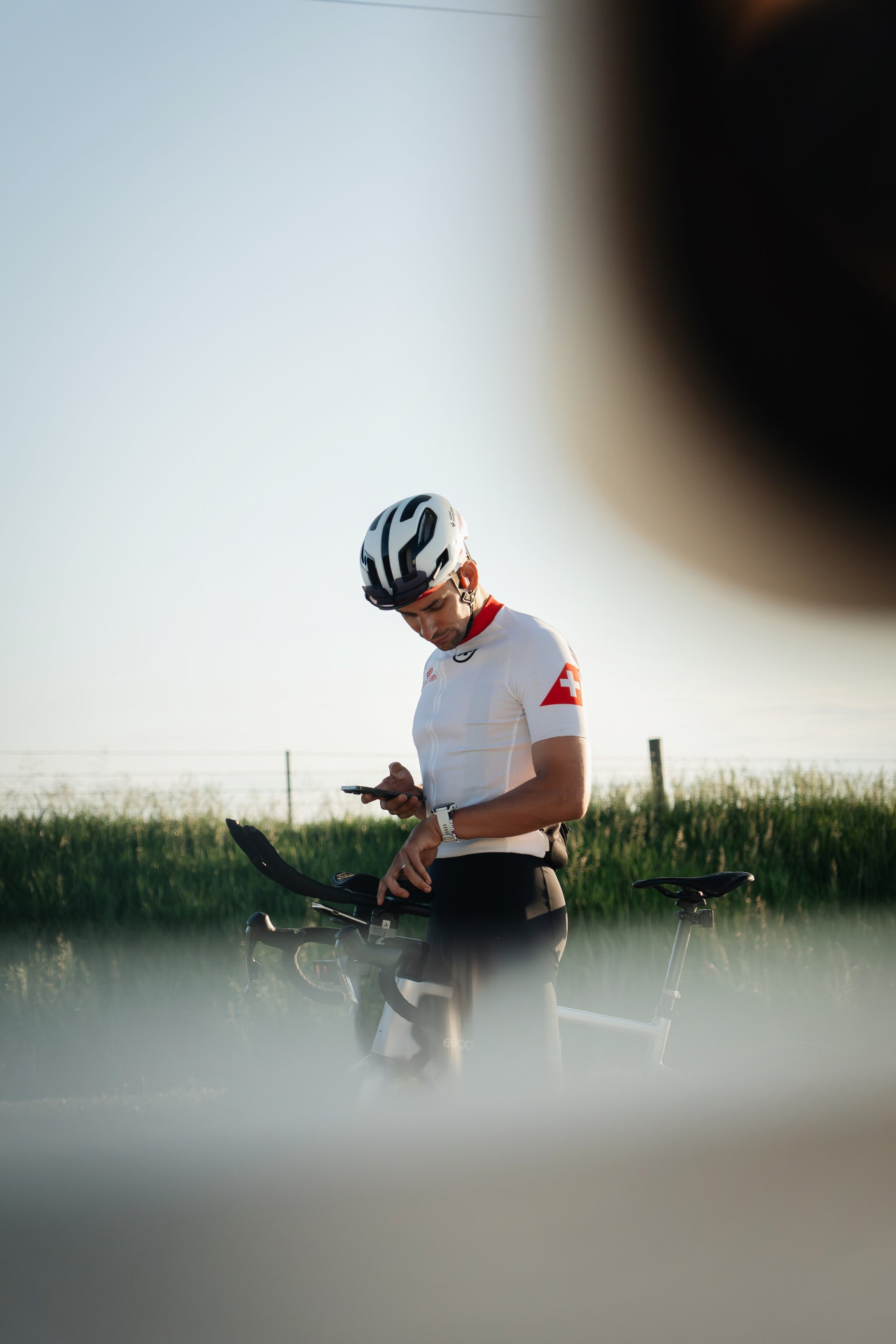 Cyclist in Swiss jersey checking phone
