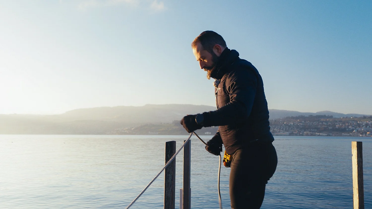 Rower holding a line on the dock by the water